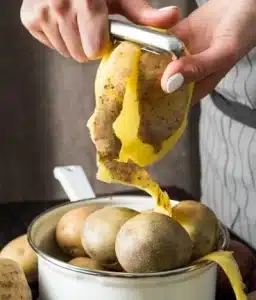 Using a potato peeler, begin by peeling the potatoes. for Texas Roadhouse Mashed Potatoes Recipe.