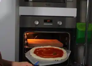 the dough is about 8"or 9", spread the pizza sauce on it and put it in the oven for 2-3 minutes