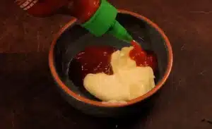 To make the sauce, first take 2 spoons of mayonnaise, 1 spoon of ketchup, 1 spoon of chili sauce in a bowl for Texas Roadhouse Cheese Fries Recipe.