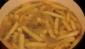 Now add two cups of steak style french fries with some salt and fry them well in a deep frying pan.