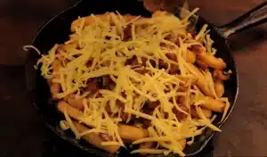 Place the French fries in an oven pan and top with the fried onions, bacon, and a cup of shredded cheese for Texas Roadhouse Cheese Fries Recipe.